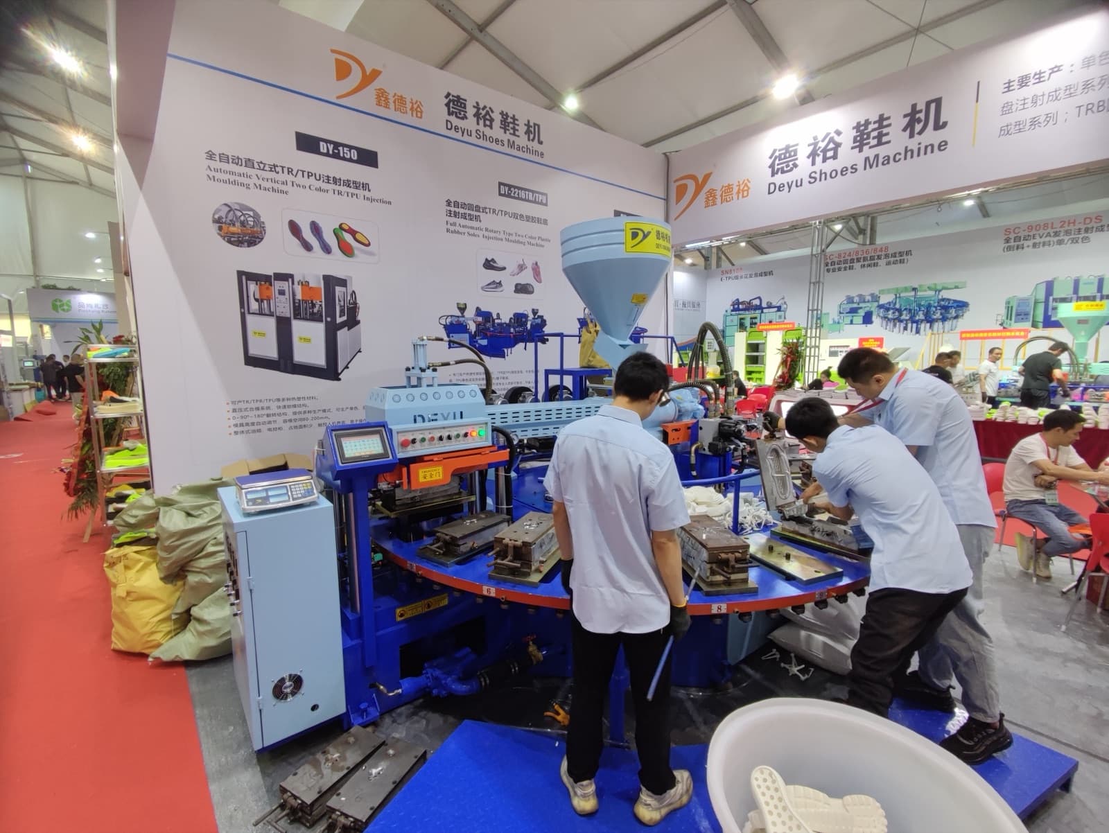 DEYU engineers running a live rotary sole injection demo at the booth