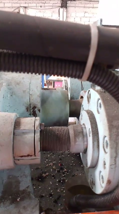 Frame from the customer's video — screw partially retracted, PVC granulate around the base.